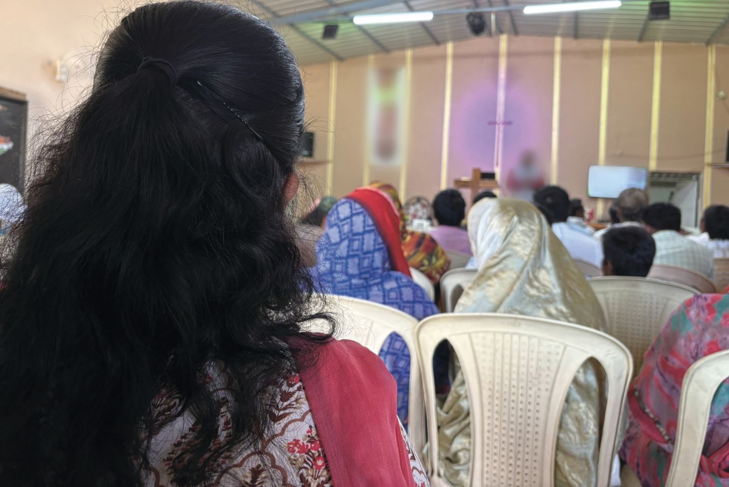 Moteris ir kiti žmonės bažnyčioje.