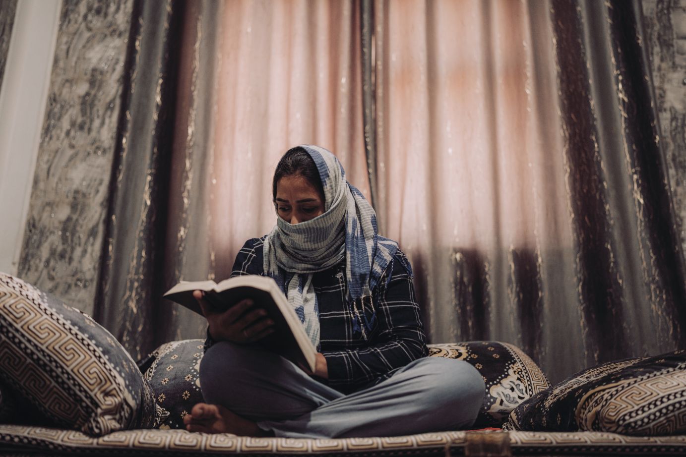 Moteris su skara skaito Bibliją.