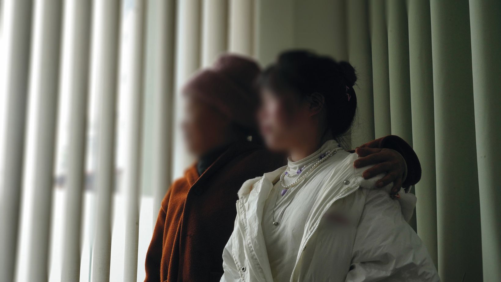 Ngoc ir jos dukra Mien žiūri pro langą.