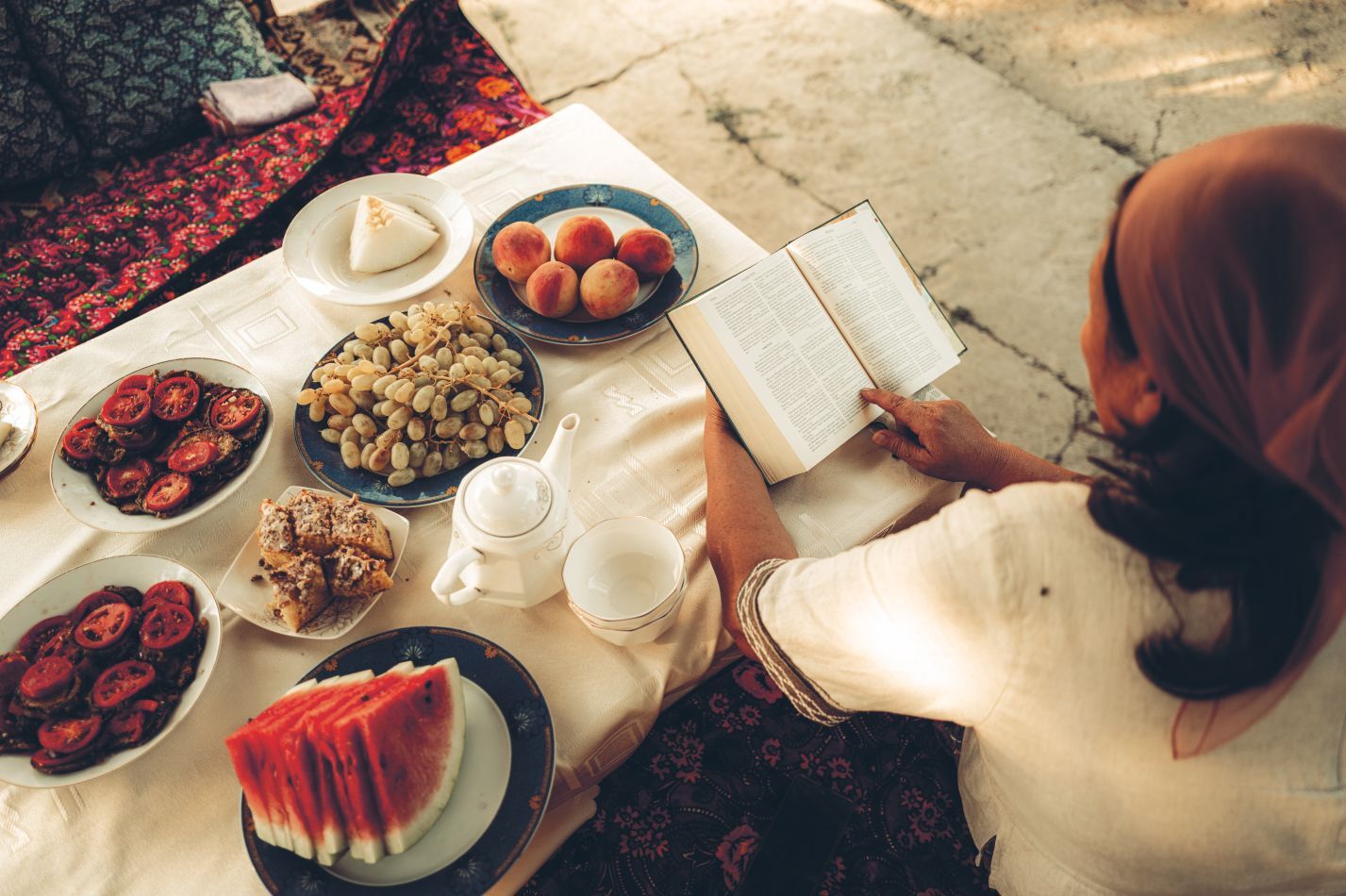 Zaira skaito Bibliją prie stalo.
